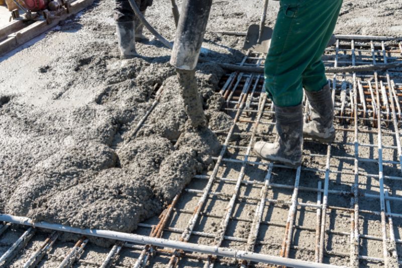 Wet concrete being poured over steel reinforcement mesh on a slab by Concrete Rockhampton Experts