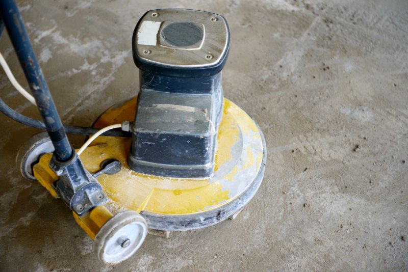 Concreter using a mechanical finishing tool to smooth a concrete surface