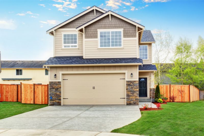 Concrete driveway leading to a single garage at a two-storey home