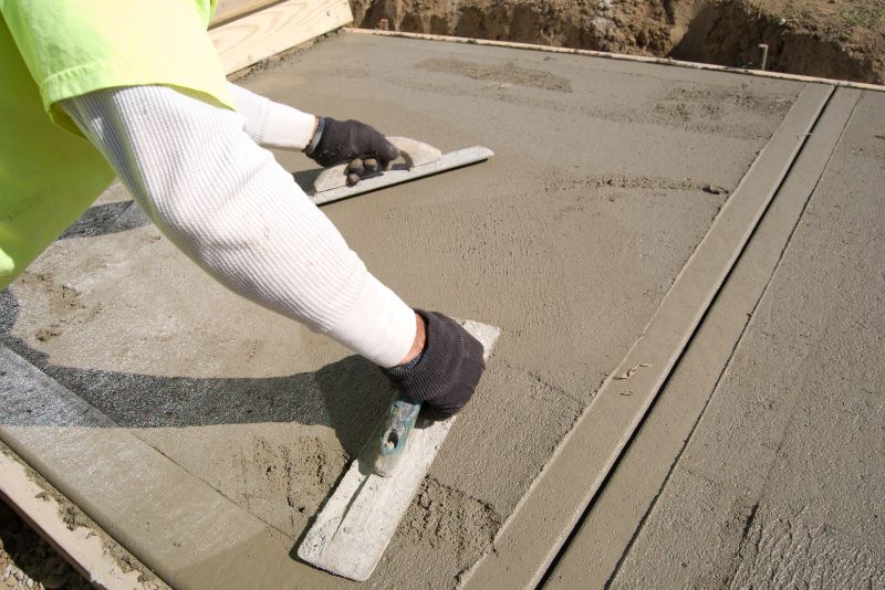 Concreter smoothing the surface of a freshly poured concrete floor