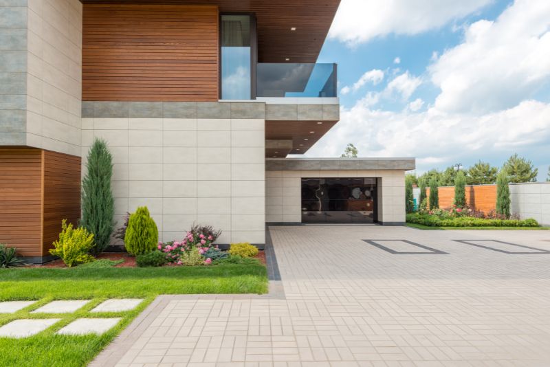 Modern home with a paved concrete driveway leading to the garage
