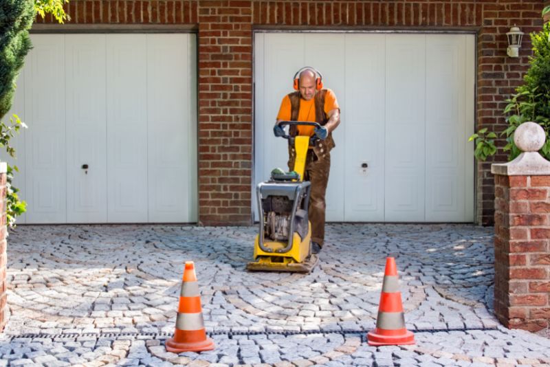 Concreter finishing a paved concrete driveway surface