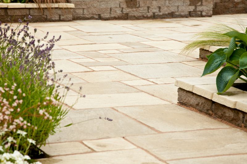Natural stone paving patio bordered by garden planting