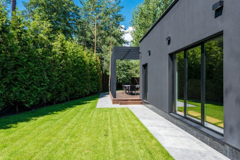 Concrete paved backyard patio and pathway bordering a lawn