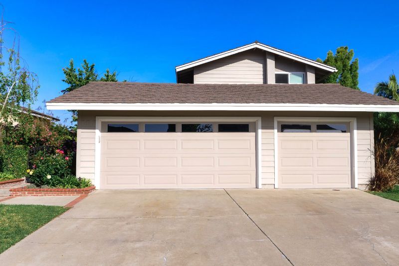 Concrete driveway leading to a double garage at a suburban home